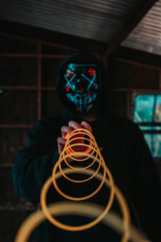 a man in a black hoodie with a neon ring around his neck, by Adam Marczyński, pexels contest winner, holography, string puppet, nerf or nothing, the pyro, instagram picture