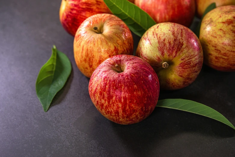 a bunch of apples sitting on top of a table, on a dark background, vibrant foliage, promo image, on grey background