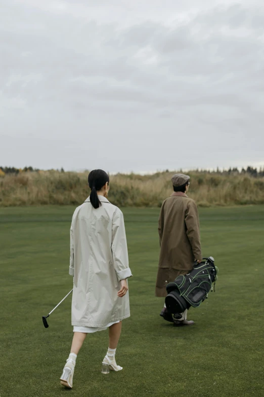 a couple of people that are standing in the grass, golf course, grey robes, walking to the right, game