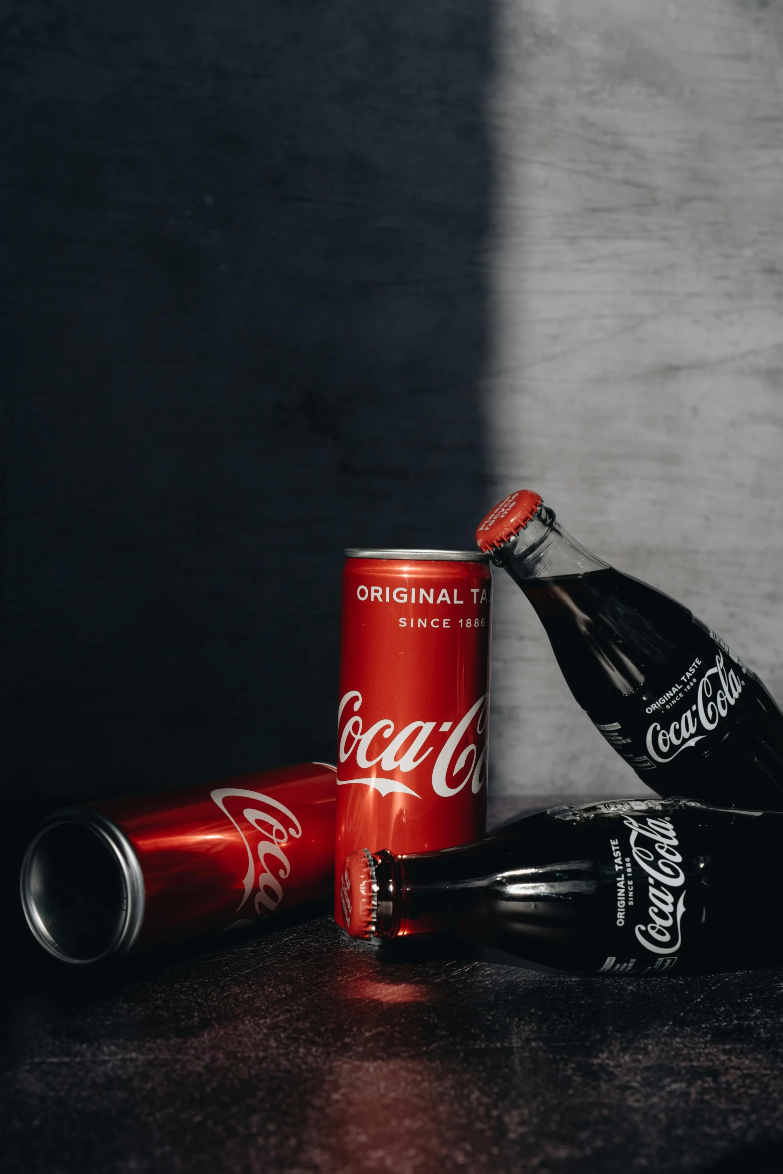 a couple of coke cans sitting on top of a table, standing with a black background, high quality product image”, reds, bottle