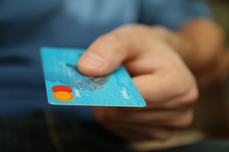 a close up of a person holding a credit card, pexels contest winner, plasticien, blue and orange, royal commission, at home, promo image