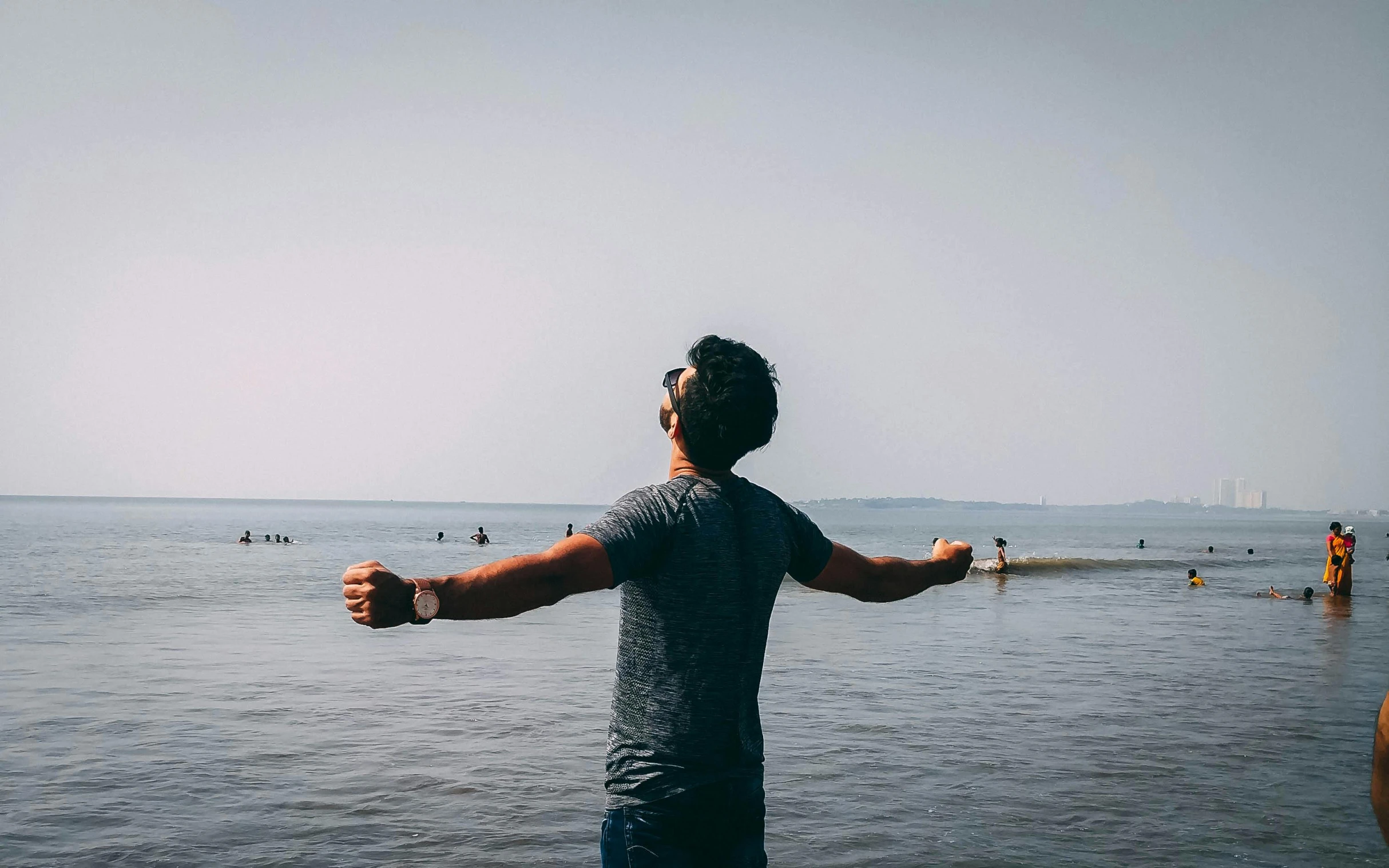 a man standing in the middle of a body of water, pose(arms up + happy), gazing at the water, profile pic, multiple stories
