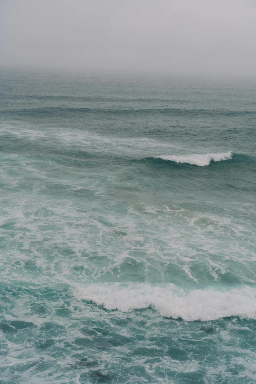 a man riding a surfboard on top of a wave in the ocean, inspired by Elsa Bleda, trending on unsplash, minimalism, 2 5 6 x 2 5 6 pixels, overcast, nazare (portugal), looking threatening