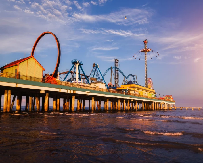 a ferris wheel sitting on top of a pier next to the ocean, roller coasters, david a trampier, lê long, gulf