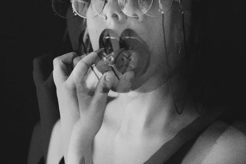 a black and white photo of a woman eating a donut, inspired by Hans Bellmer, transparent glasses, smoking a cigarrette🚬, 1 9 7 0 s analog aesthetic, brandon woelfel