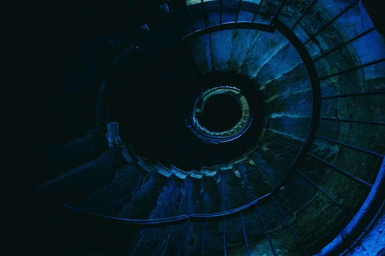 a spiral staircase in a dark room, an album cover, inspired by Elsa Bleda, unsplash contest winner, deep blue sea color, inside a tomb, nightlife, blue