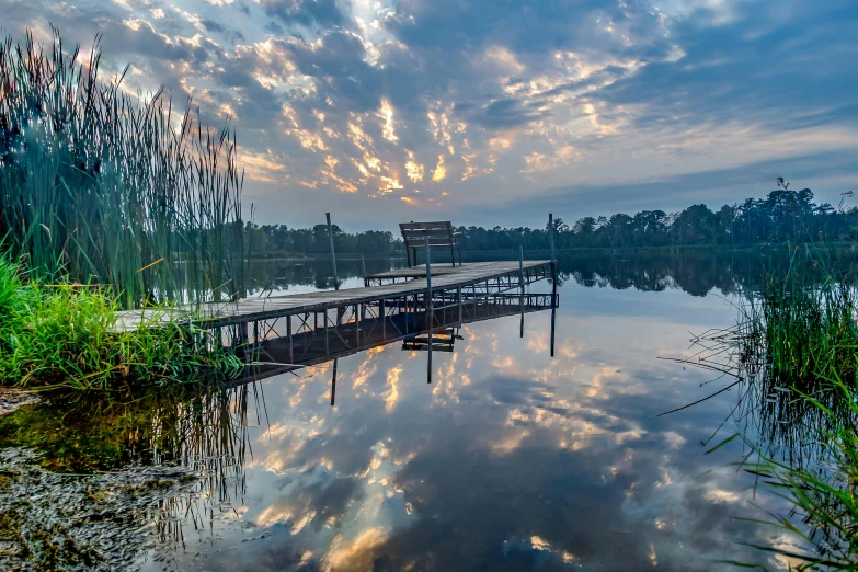 a dock sitting on top of a lake under a cloudy sky, by Jan Rustem, alabama, fan favorite, golden hour intricate, slide show