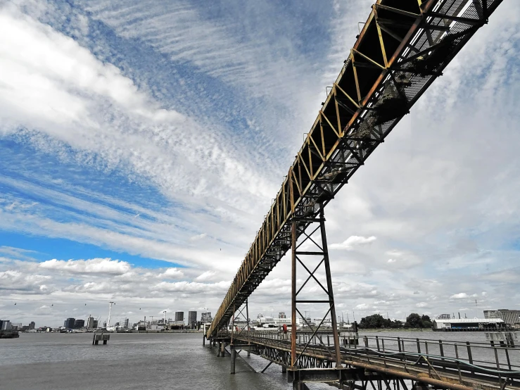 a bridge over a body of water under a cloudy sky, pexels contest winner, photorealism, industrial colours, melbourne, te pae, thumbnail