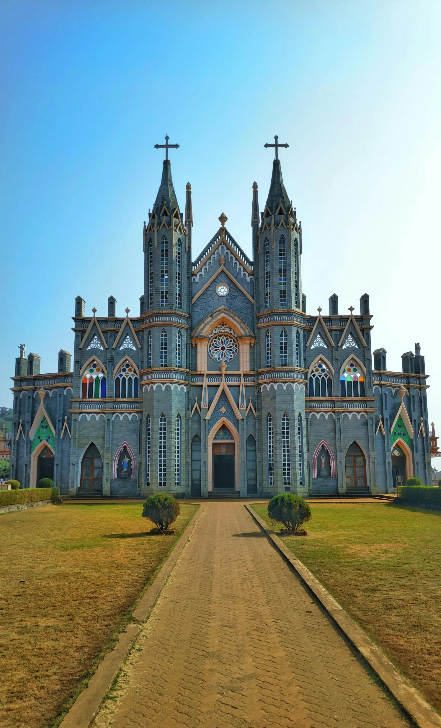 a large church sitting on top of a lush green field, glossy intricate design, guwahati, seaside victorian building, front elevation view