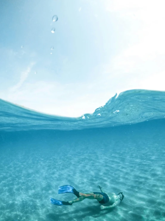 a person swimming in the ocean with a snorg, view from the ground, light blue water, chillwave, high-quality photo