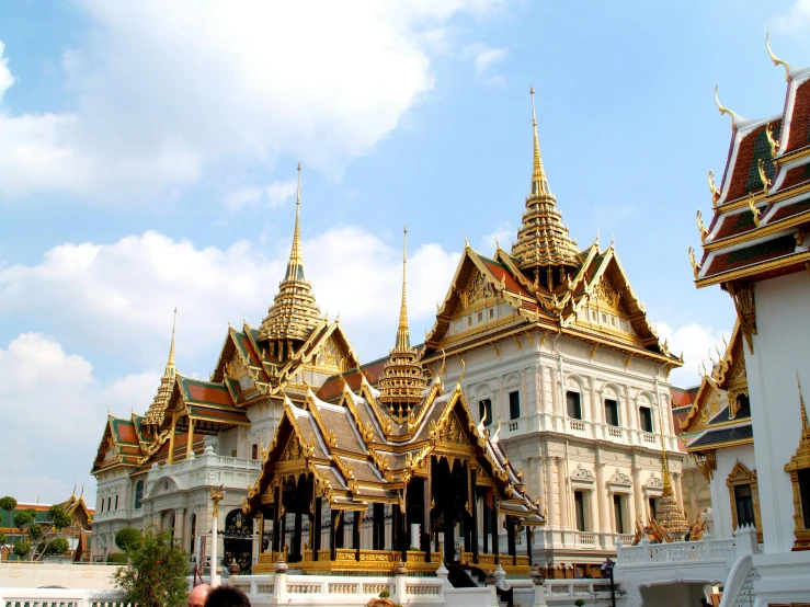 a group of people standing in front of a building, pexels contest winner, baroque, thai architecture, white and gold color scheme, square, youtube thumbnail