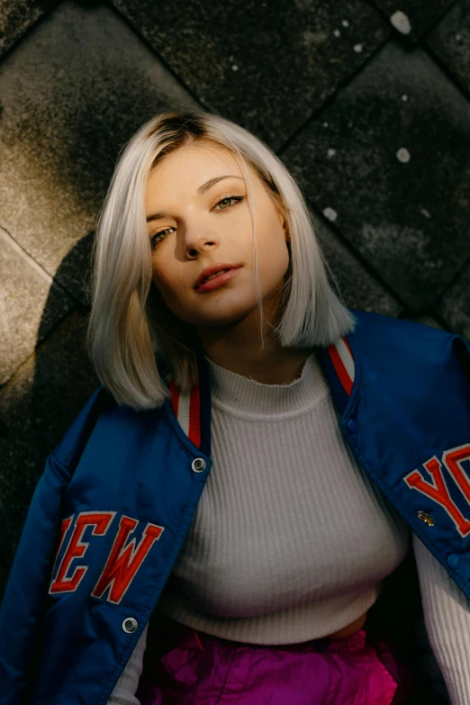 a woman sitting on the ground wearing a new york jacket, white blonde hair, portrait sophie mudd, promo image, miranda cosgrove