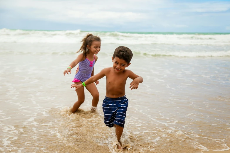 two children playing in the water at the beach, by Alison Debenham, pexels contest winner, puerto rico, running towards camera, boy and girl, thumbnail