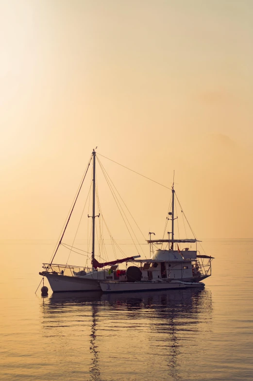 a boat floating on top of a body of water, at the golden hour, on the ocean, three masts, tranquil