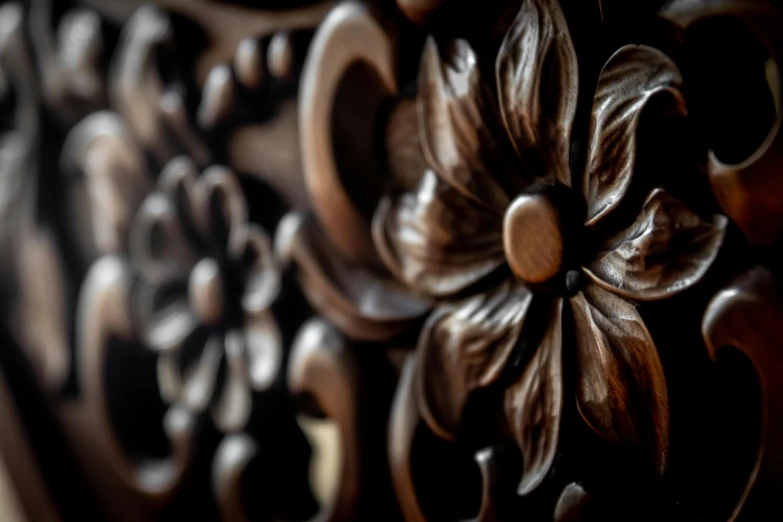 a close up of a carved wooden bench, inspired by Nōami, pexels contest winner, arts and crafts movement, dark flower pattern wallpaper, intricate detail. unreal engine, shot on sony a 7 iii, swirling flowers