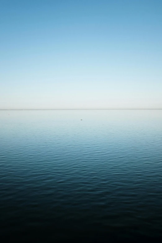 a large body of water with a boat in the distance, by Peter Churcher, minimalism, minn