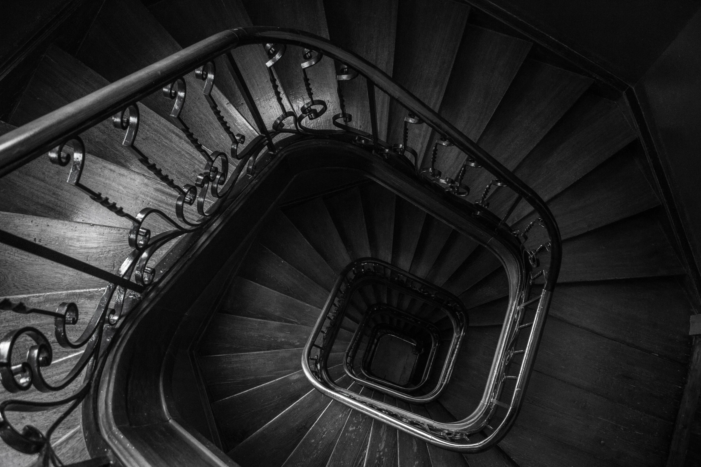 a black and white photo of a spiral staircase, by Daniel Gelon, unsplash contest winner, baroque, wooden stairs, best on cgsociety, “diamonds, mansion