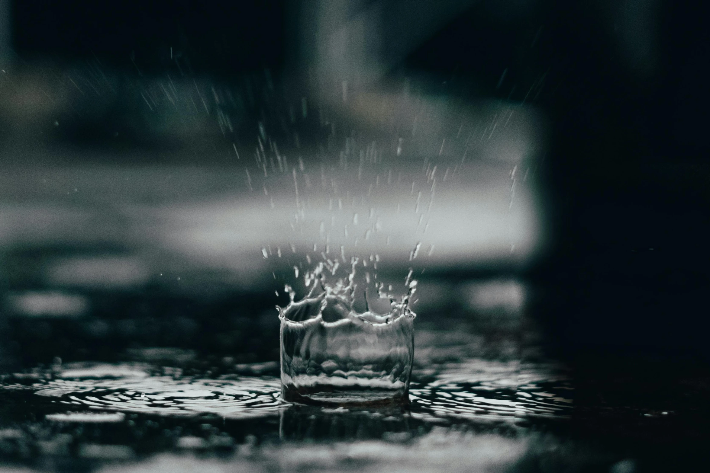 a glass filled with water sitting on top of a table, by Emma Andijewska, unsplash contest winner, visual art, rain splashing, floating crown, instagram post, black water