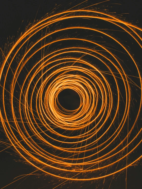 a spiral of light on a black background, an album cover, trending on unsplash, orange electricity, technological rings, grainy, full frame image