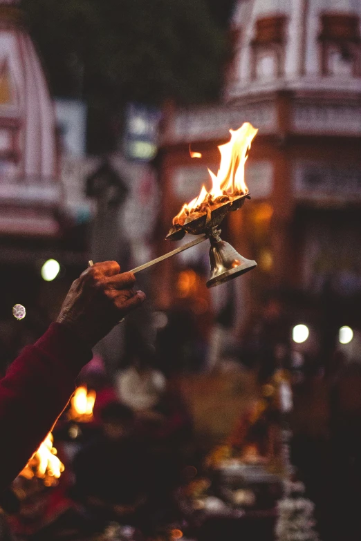 a person holding a fire stick in front of a building, a picture, trending on unsplash, renaissance, hindu gods, emerging from a lamp, nepal, square