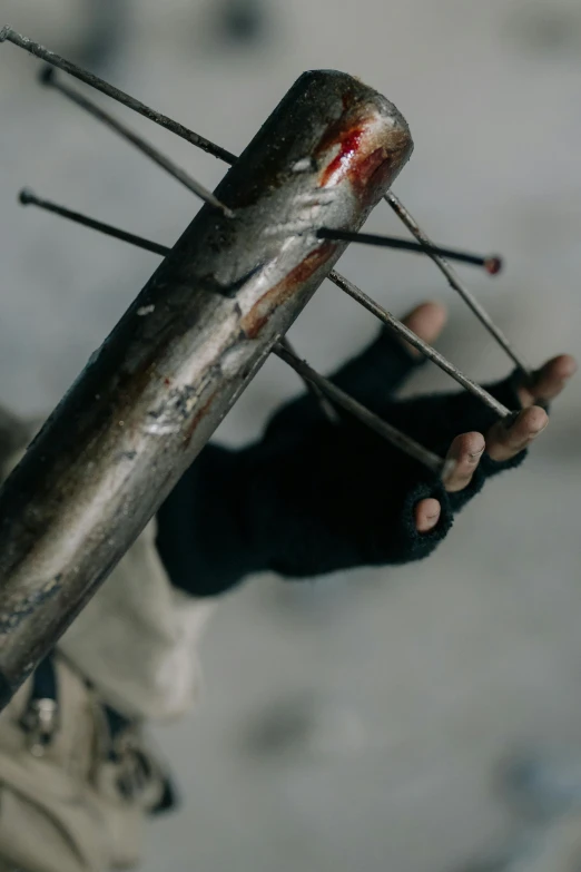 a close up of a person holding a stick, by Attila Meszlenyi, crucifixion, sharp metal claws, hbo, b - roll