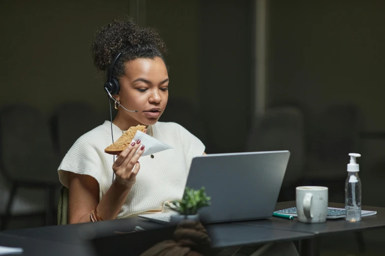 a woman sitting in front of a laptop eating a piece of pizza, trending on pexels, wearing headset, avatar image, professional photo, eating garlic bread