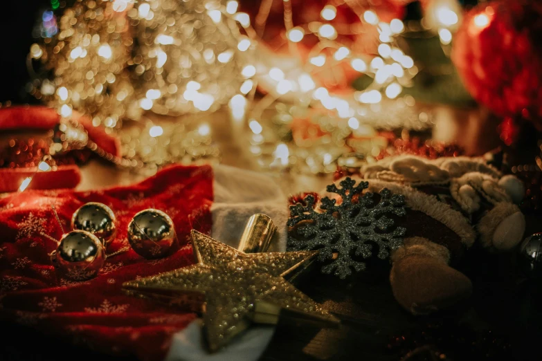 a pile of presents on a table with a christmas tree in the background, pexels contest winner, glittering multiversal ornaments, background image, red and gold cloth, string lights