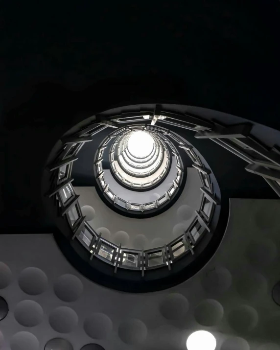 a spiral staircase in a building at night, inspired by Alexander Rodchenko, unsplash contest winner, photo of a dyson sphere, 3/4 view from below, hyperrealism photography, ilustration