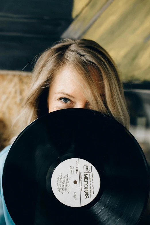 a woman holding a record in front of her face, trending on pexels, long blonde hair and large eyes, discord profile picture, soft vinyl, black