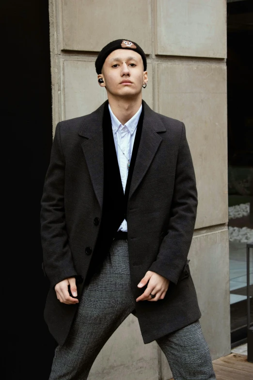 a man is standing in front of a building, an album cover, inspired by Joong Keun Lee, unsplash, renaissance, wearing black overcoat, grey pants and black dress shoes, portrait of tom holland, asian man