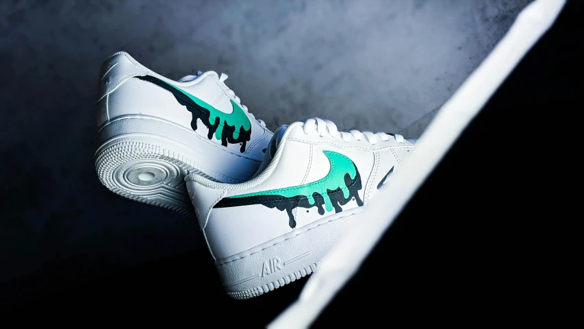 a pair of white shoes with green paint on them, an airbrush painting, by Paul Bird, trending on unsplash, airforce gear, drip, from the side, swoosh