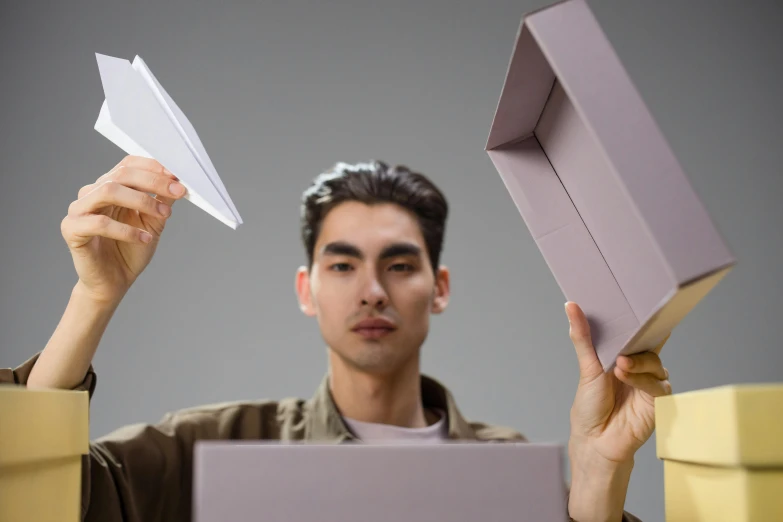 a man holding a box and a paper airplane, inspired by Russell Dongjun Lu, pexels contest winner, conceptual art, avatar image, multi-part, luts, writing a letter