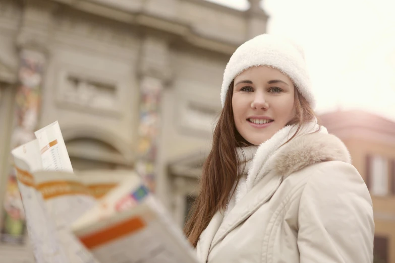 a woman in a white hat is reading a newspaper, pexels contest winner, wearing a white winter coat, tourist, girl with brown hair, avatar image