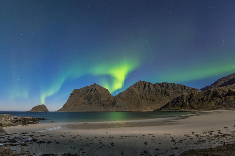 the aurora lights in the sky over a body of water, by Nikolaj Abraham Abildgaard, pexels contest winner, mountains and ocean, sitting on the beach at night, blue and green, autumn season