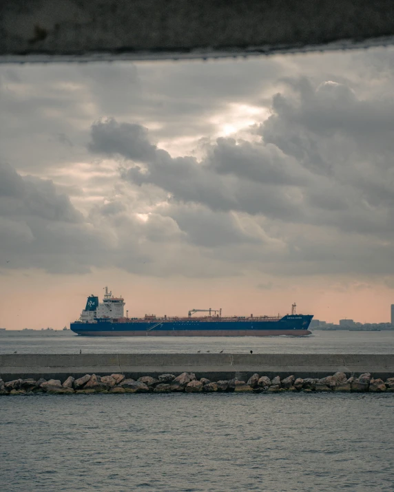 a large cargo ship sitting on top of a body of water, by Jacob Burck, pexels contest winner, transgender, lgbtq, set photo