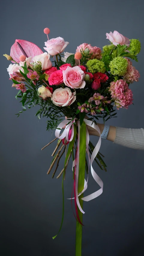 a woman holding a bouquet of pink and green flowers, dribble, wrapped in flowers, large tall, on a gray background, soft bloom lighting