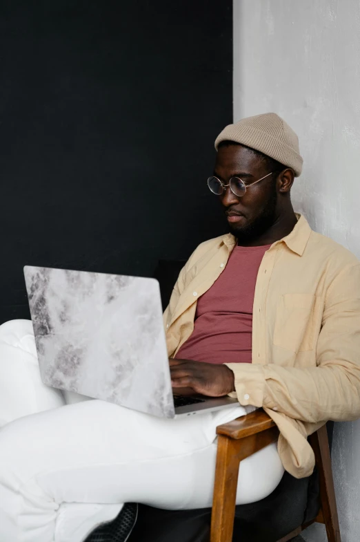 a man sitting in a chair with a laptop, trending on pexels, renaissance, grey skinned, ( ( dark skin ) ), an all white human, brown