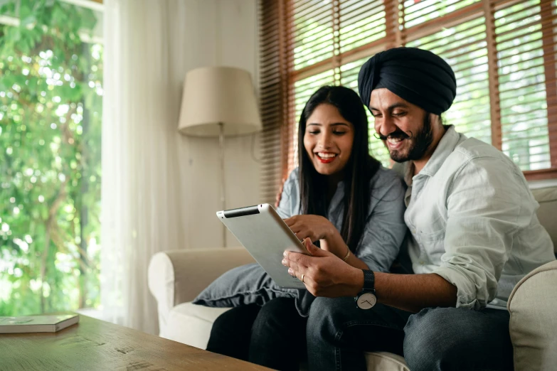 a man and woman sitting on a couch looking at a tablet, indian, excited, thumbnail, list