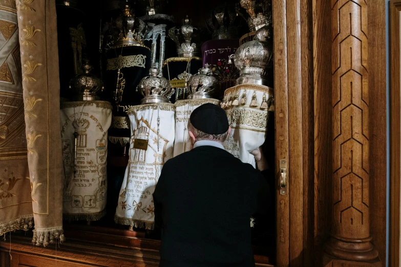 a man is standing in front of a shrine, by Julia Pishtar, pexels contest winner, baroque, hebrew, hiding, decoration, a person standing in front of a