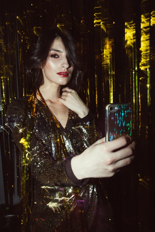 a woman taking a picture of herself in a mirror, a picture, inspired by Elsa Bleda, trending on pexels, holography, at the party, gilded outfit, gemma chan girl portrait, brunette