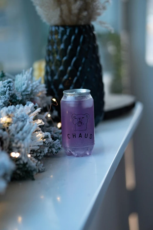 a candle sitting on top of a table next to a christmas tree, a picture, by Chase Stone, bauhaus, light purple, sherek head design as a bottle, cold drinks, product image