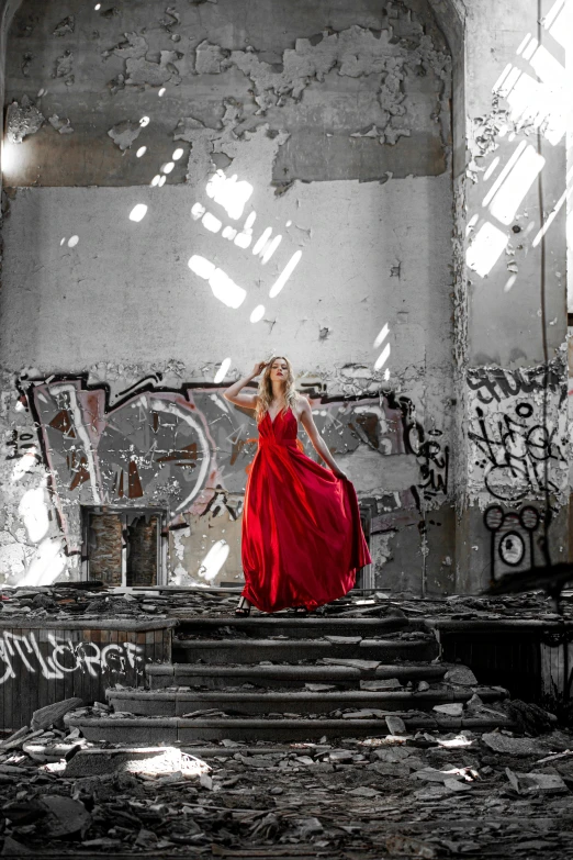 a woman in a red dress standing in an abandoned building, inspired by Annie Leibovitz, pexels contest winner, graffiti, recital, monochromatic red, concert, wearing a long dress