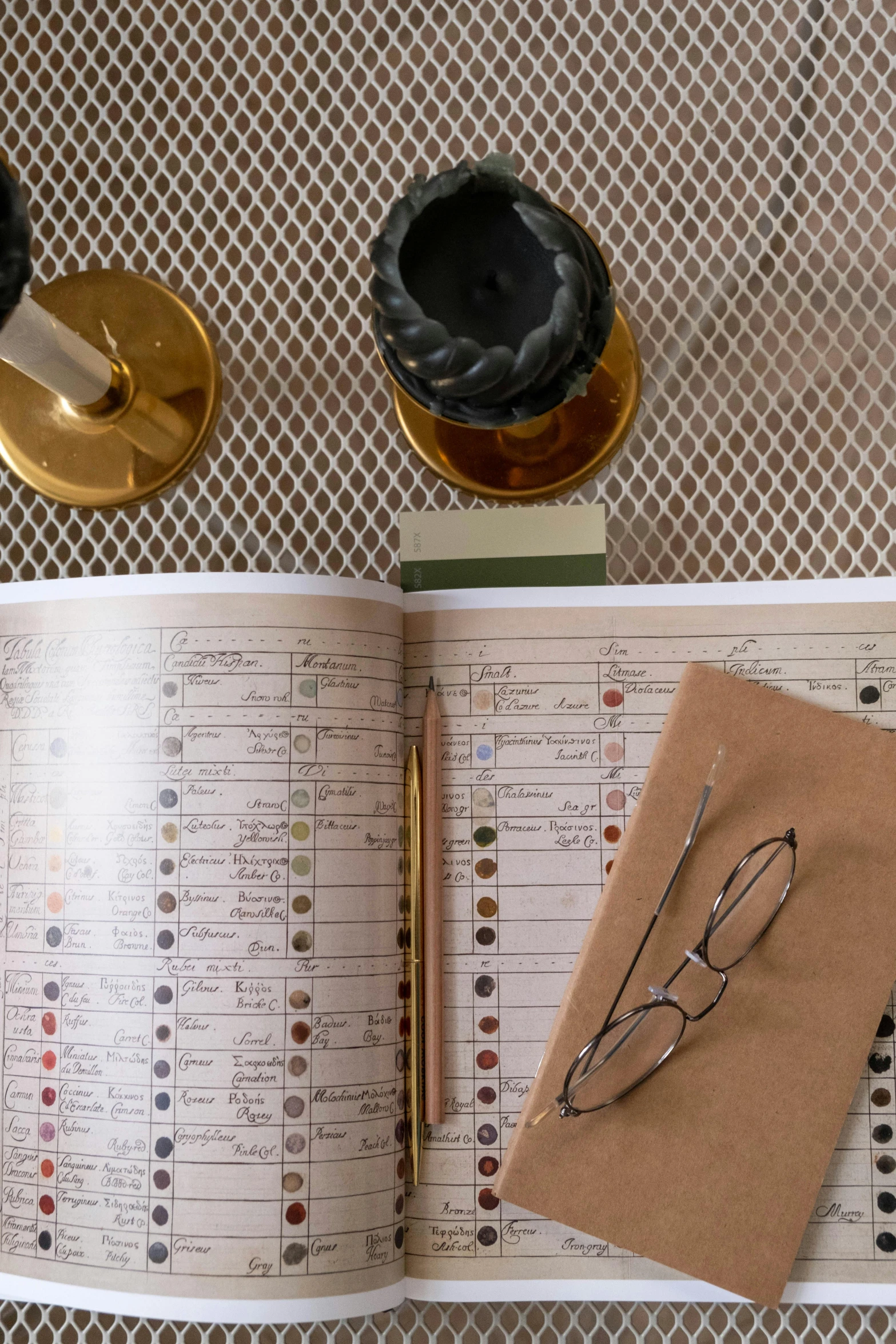 an open book sitting on top of a table, brown and gold color palette, specimens in glasses, grid of styles, drinking