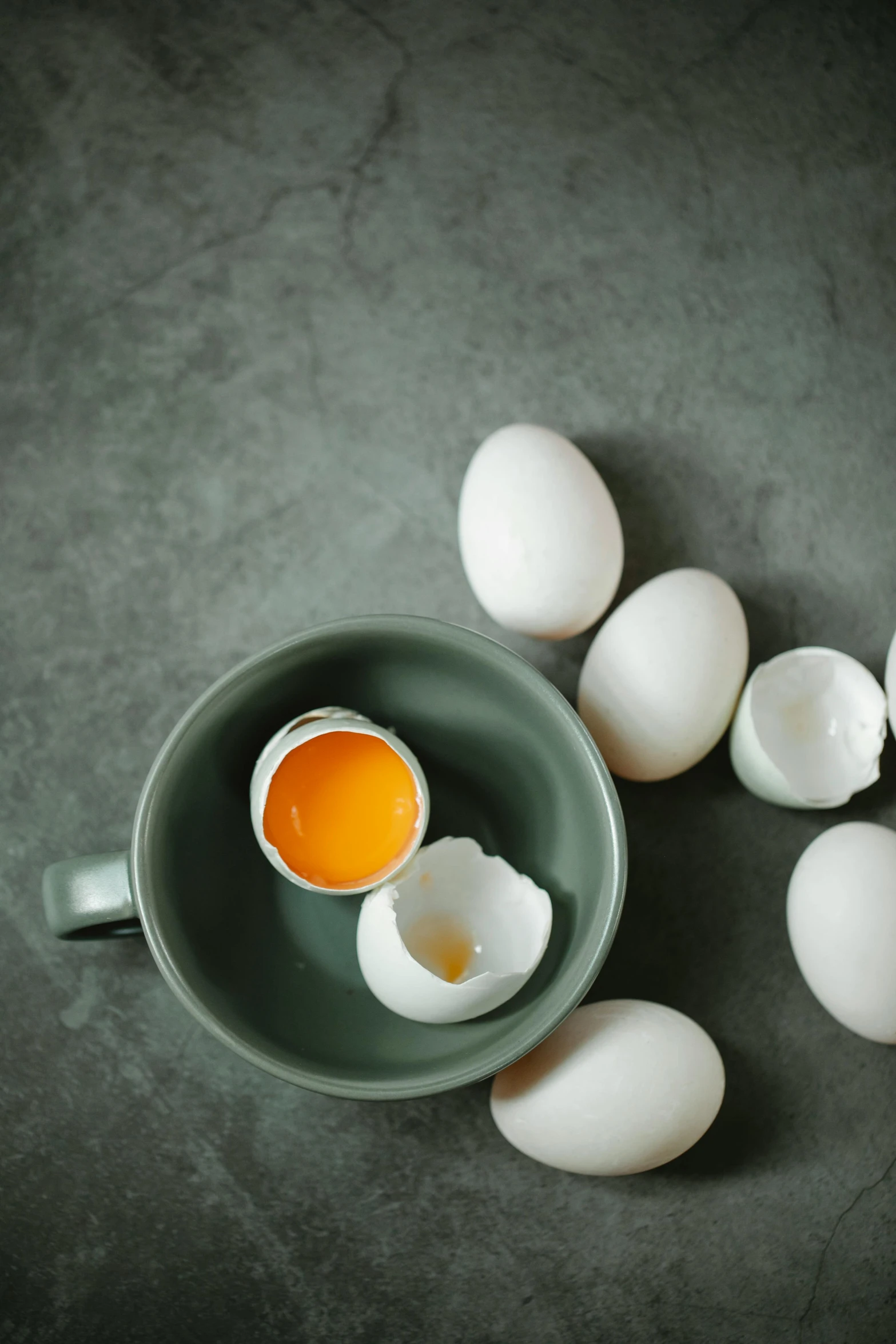 a bowl filled with eggs sitting on top of a table, a still life, trending on pexels, dau-al-set, cups and balls, cracked, vanilla, detailed product image