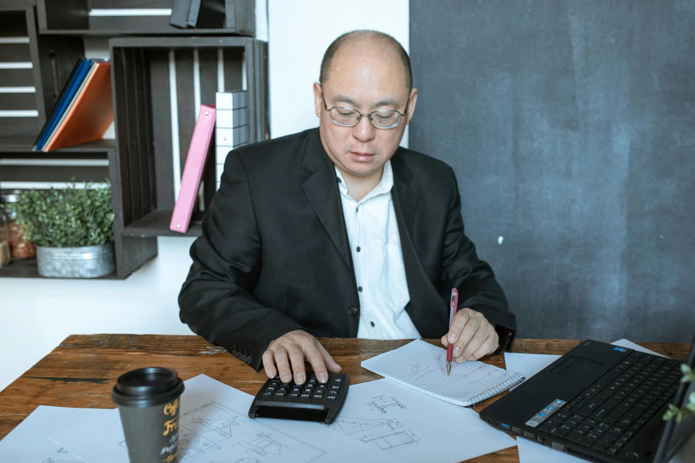 a man sitting at a table with a calculator and a laptop, pexels contest winner, gutai group, 15081959 21121991 01012000 4k, dao trong le, a man wearing a black jacket, well - drawn