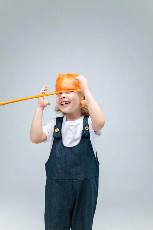 a little girl holding a stick over her head, visual art, hard hat, long and orange mustache, unsplash contest winning photo, on grey background