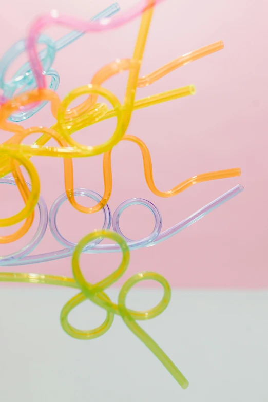 a bunch of scissors sitting on top of a table, an abstract sculpture, inspired by Cerith Wyn Evans, pastel cute slime, closeup - view, translucent neon, soft twirls curls and curves