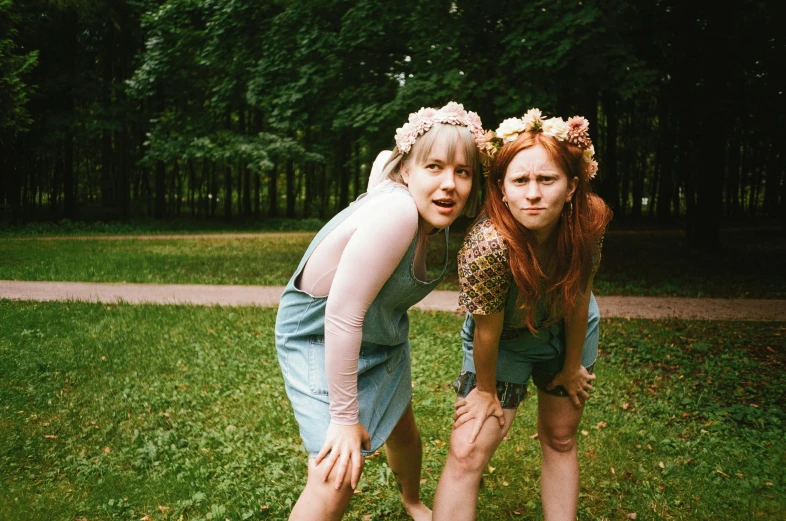 a couple of women standing on top of a lush green field, an album cover, by Emma Andijewska, tumblr, wearing a flower headpiece, in a city park, photo taken in 2 0 2 0, silly