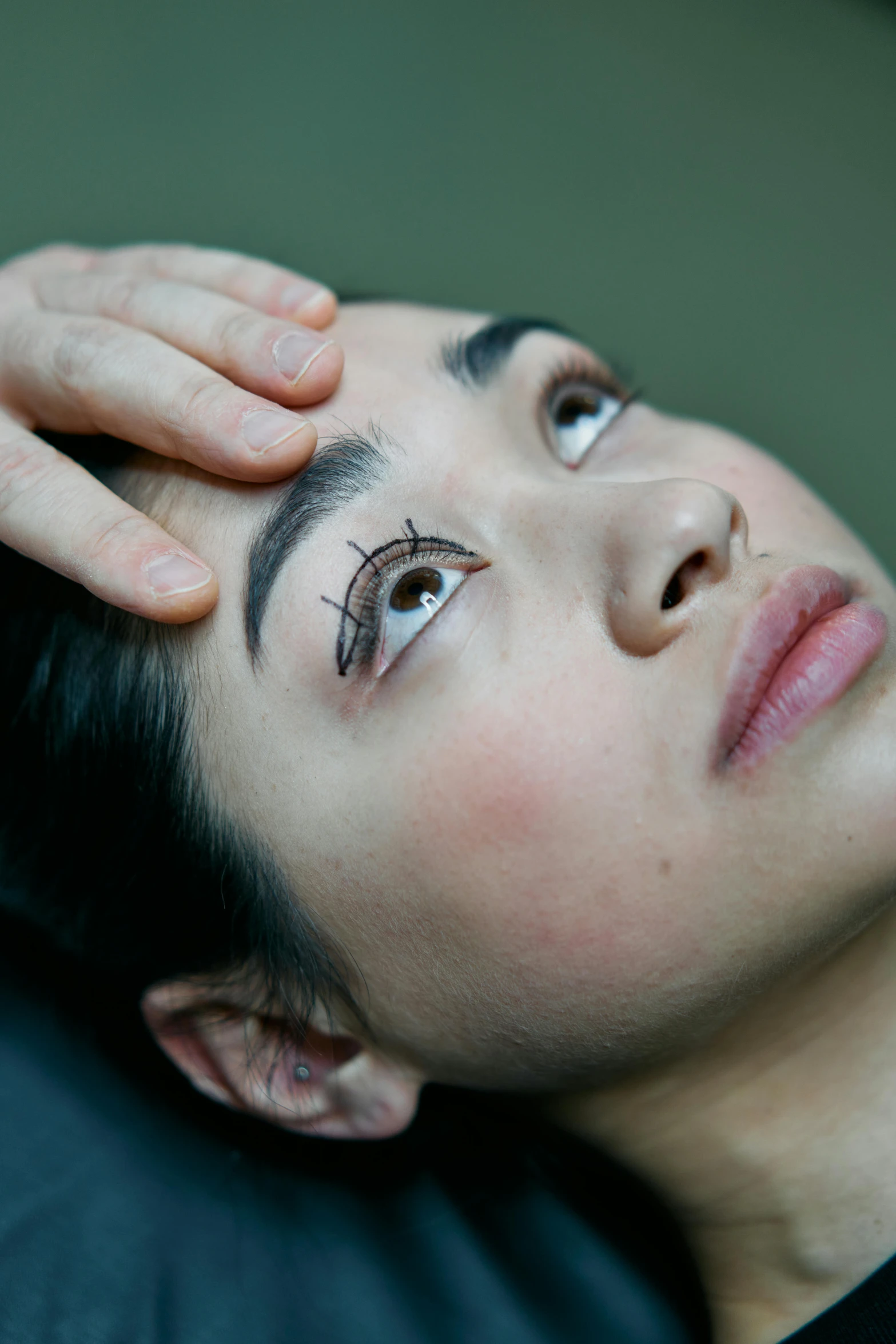 a woman with a pair of scissors on her head, a tattoo, inspired by Marina Abramović, long lashes, acupuncture treatment, brown, eye - level medium - angle shot