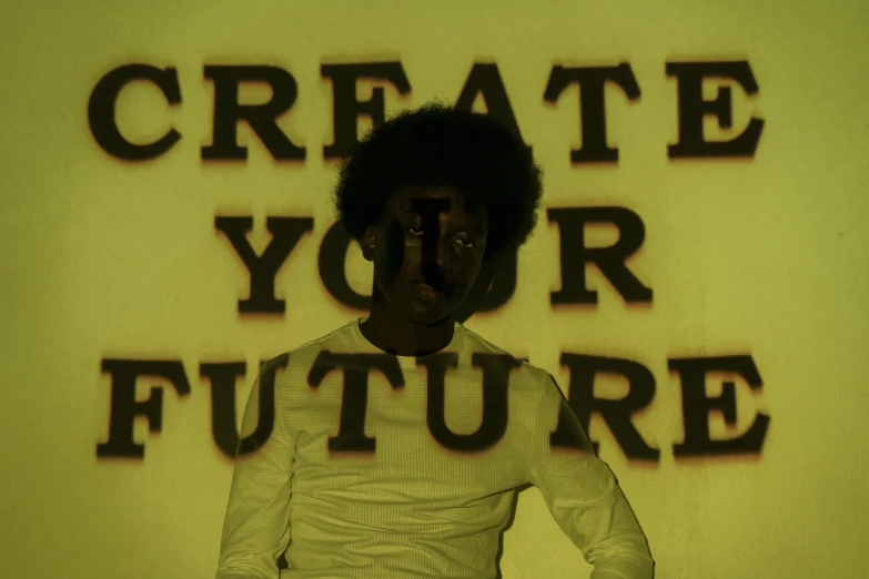 a woman standing in front of a sign that says create your future, an album cover, inspired by Carrie Mae Weems, afrofuturism, black man with afro hair, yellow infrared, concert photo, off white